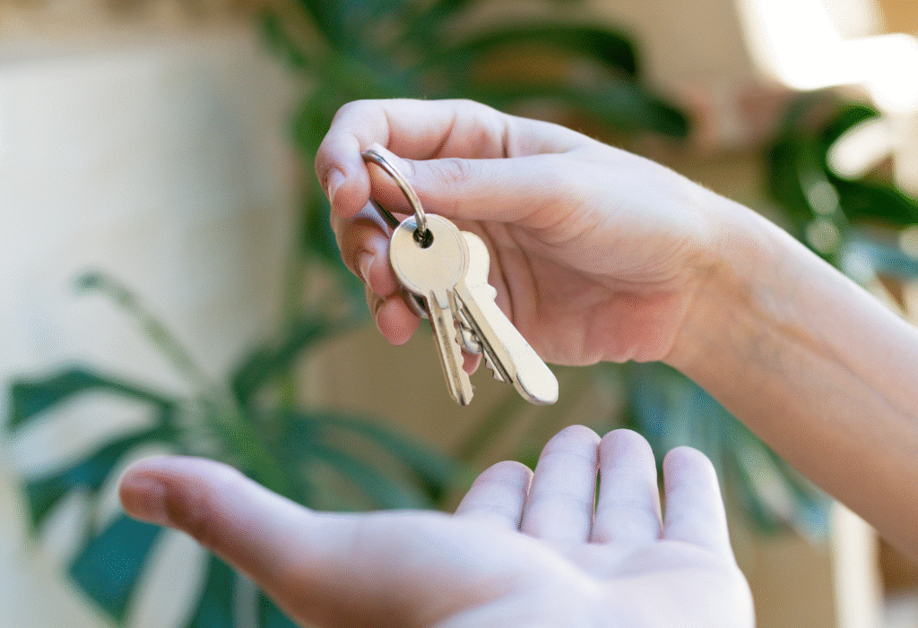 Une main donne des clés à une autre main